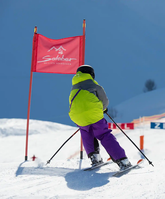 Een jonge cursist gaat over de finish in een skiwedstrijd