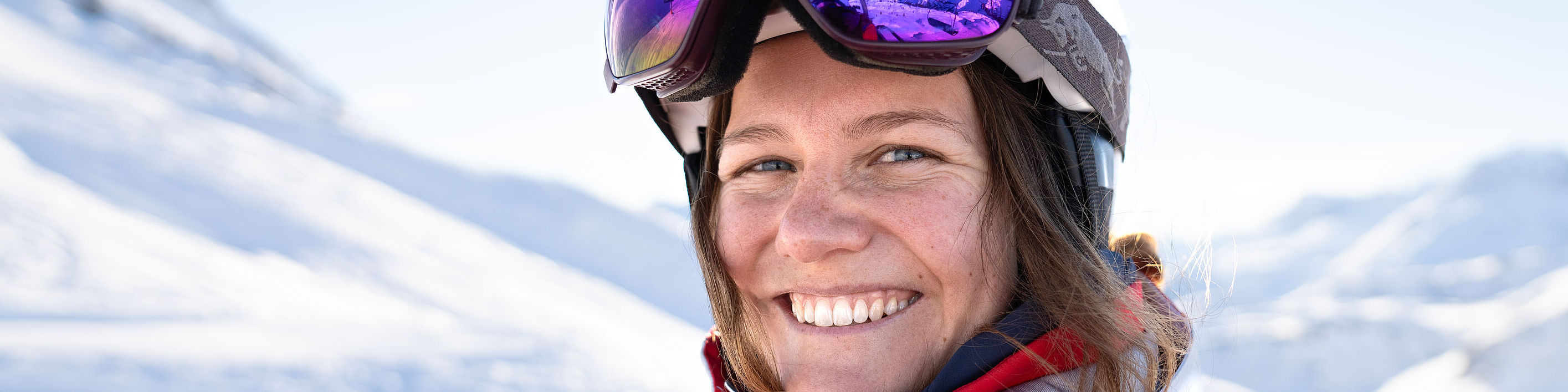 Skilehrerin Lisa sitzt lächelnd im Sessellift