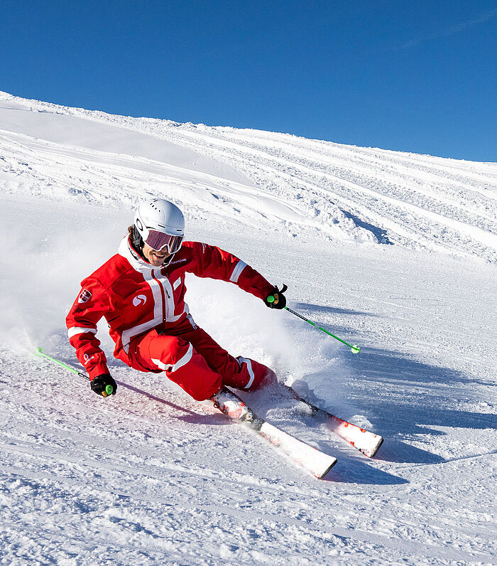Ski instructor Rick is carving in a long turn