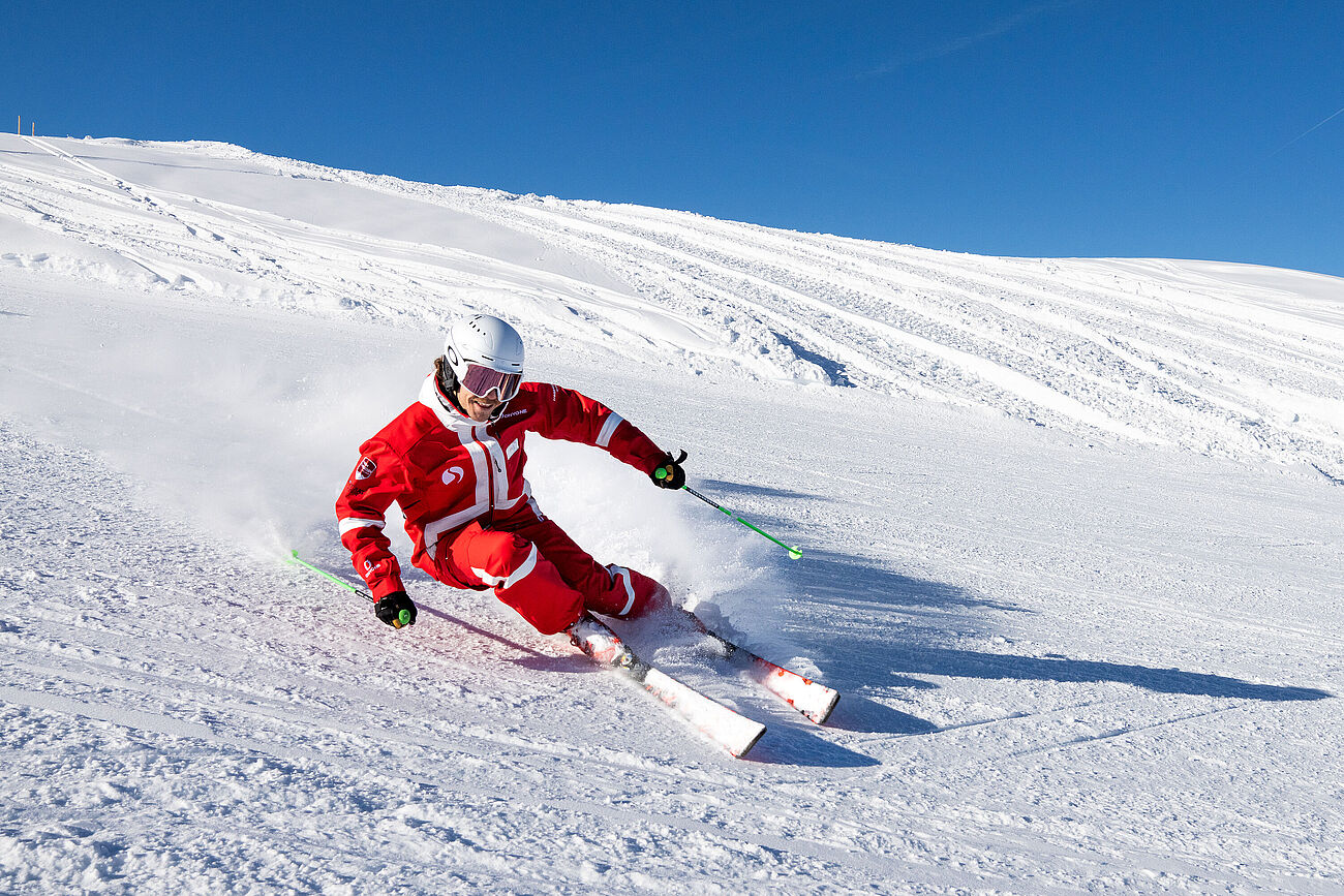 Ski instructor Rick is carving in a long turn